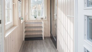 A narrow hallway with wooden walls and a window with a view of trees. There is a door on the right and a window on the left. - Modern Ferienhaus Nahe von Winterberg mit Garten (Winterberg)