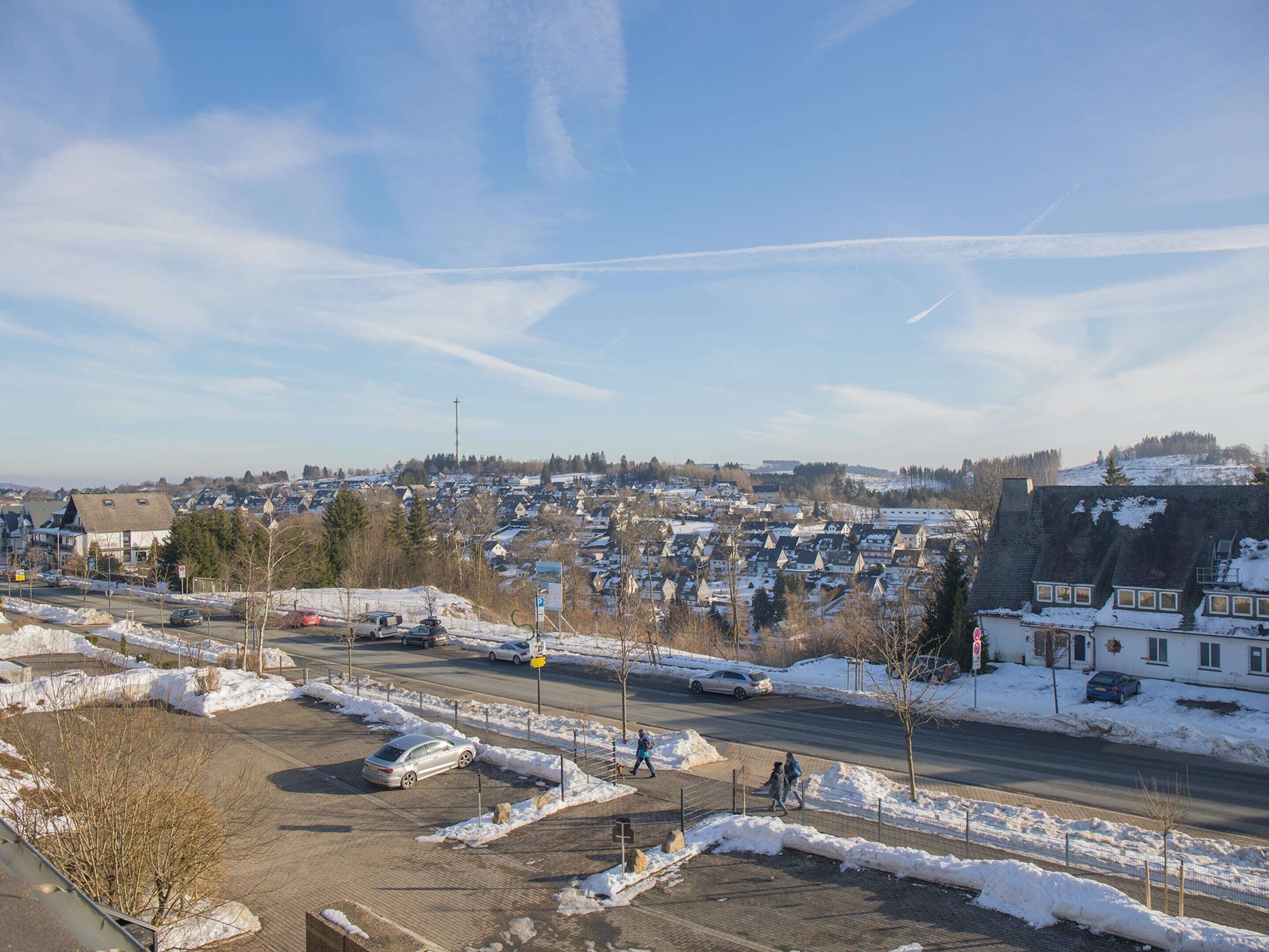 A residential area with houses, a road, and a parking lot.