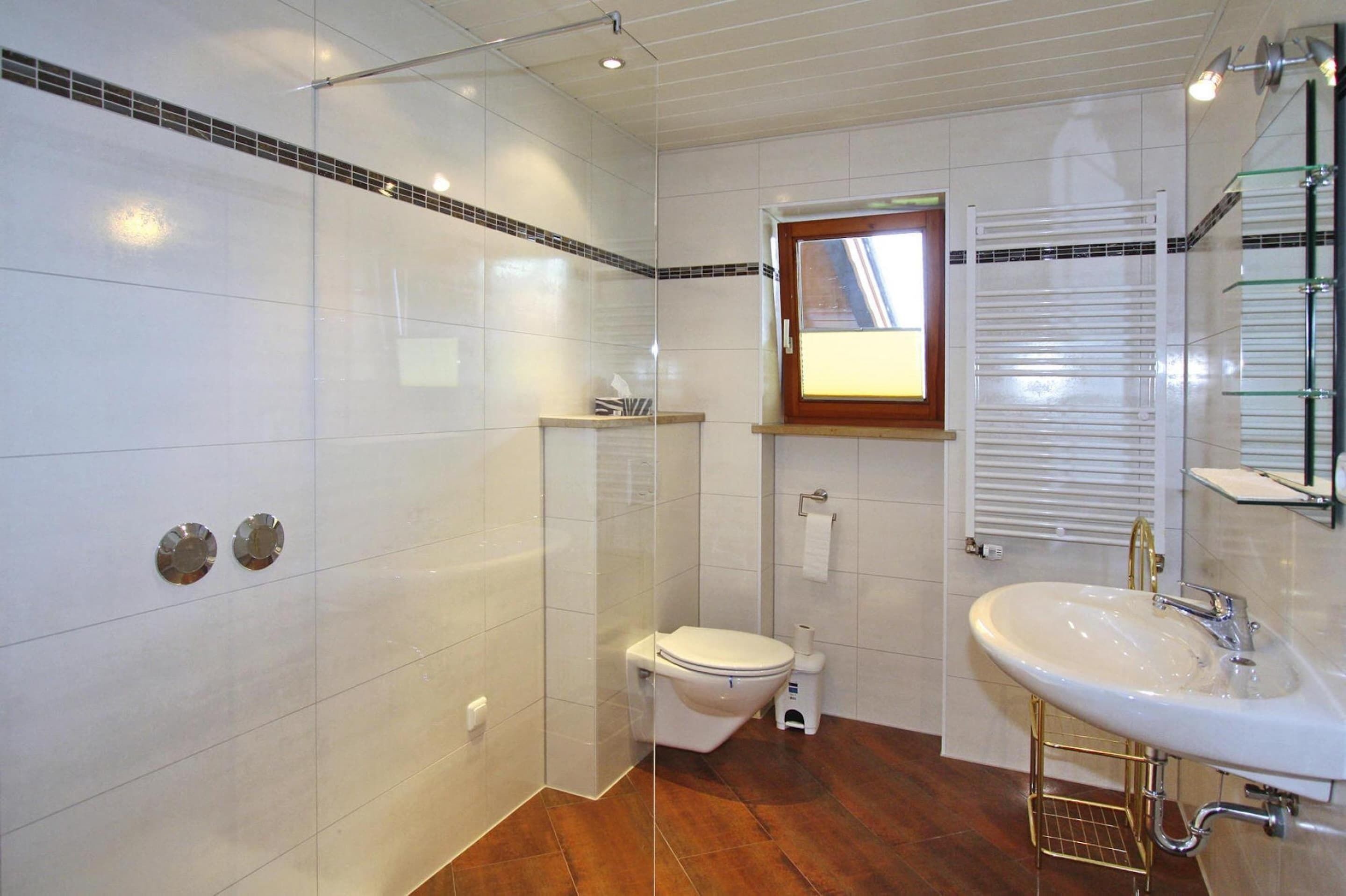 Une salle de bain avec des toilettes, un lavabo et une douche.