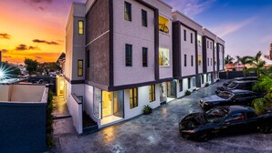 Un edificio moderno de varios pisos con un área de estacionamiento al frente.