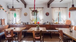 A traditional European-style dining room with wooden furniture, a bench seating area, and decorative elements like curtains and wall hangings. - Exklusives Ferienhaus in Sankt Goarshausen (Sankt Goarshausen)
