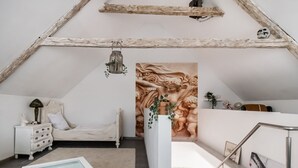A bedroom with a bed, nightstand, dresser, and a glass-top table with decorative items. - Luxurious Holiday Home With a Nice Private Garden (Anschau)