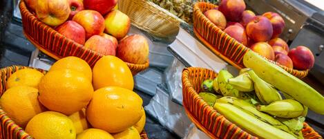 Three wicker baskets filled with fruits including apples, oranges, and bananas.