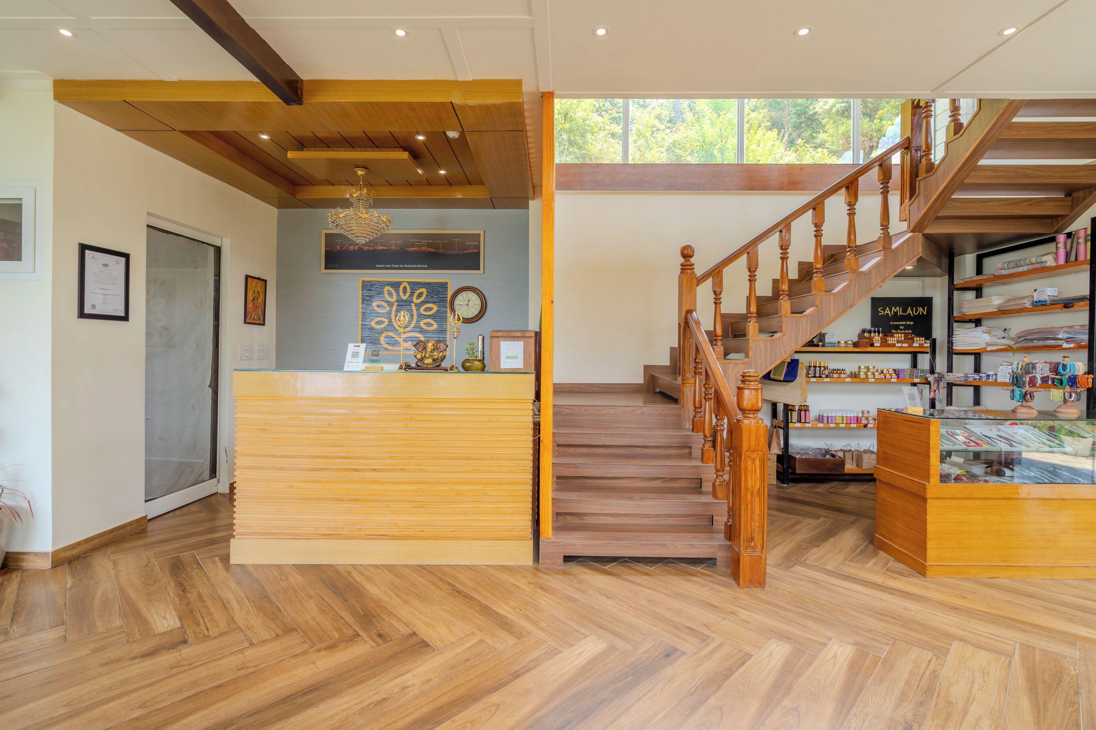 A reception area with a wooden desk, a staircase, and a display of items on shelves.