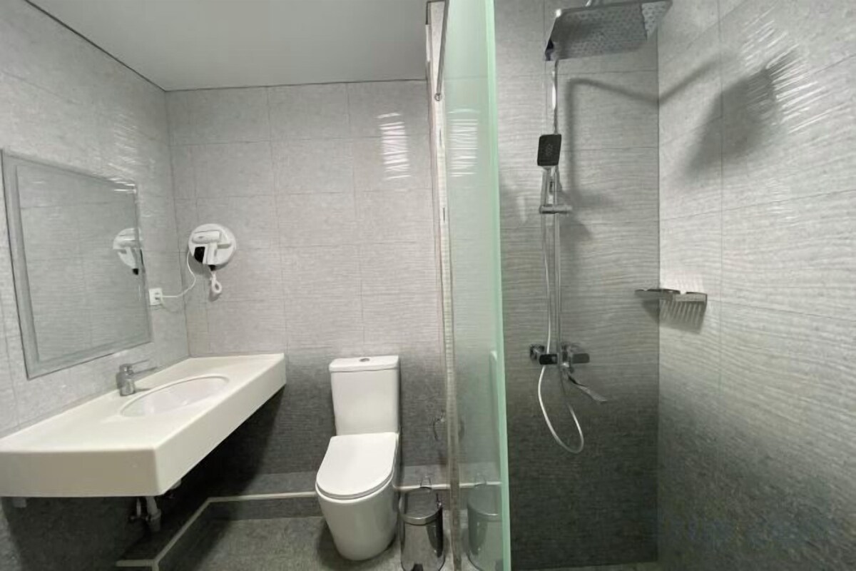 A bathroom with a sink, toilet, and glass-enclosed shower.