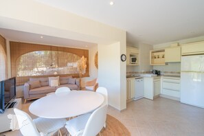 A modern kitchen with white cabinets, a microwave, and a refrigerator.