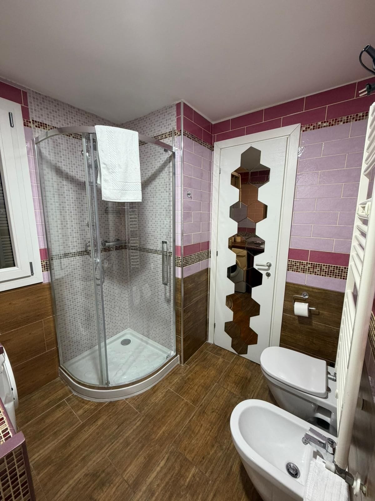 Un baño con cabina de ducha de vidrio, un inodoro blanco y un lavabo.