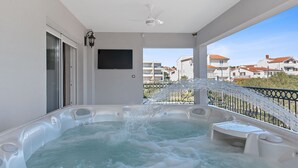 Un jacuzzi en un balcón con vistas a edificios.