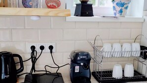 A kitchen with a coffee maker, a toaster, a kettle, and a dish rack with cups. - Apartment in Gammertingen With Terrace (Gammertingen)