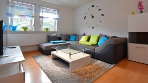 Ett modernt vardagsrum med en soffa, ett soffbord och en väggklocka.