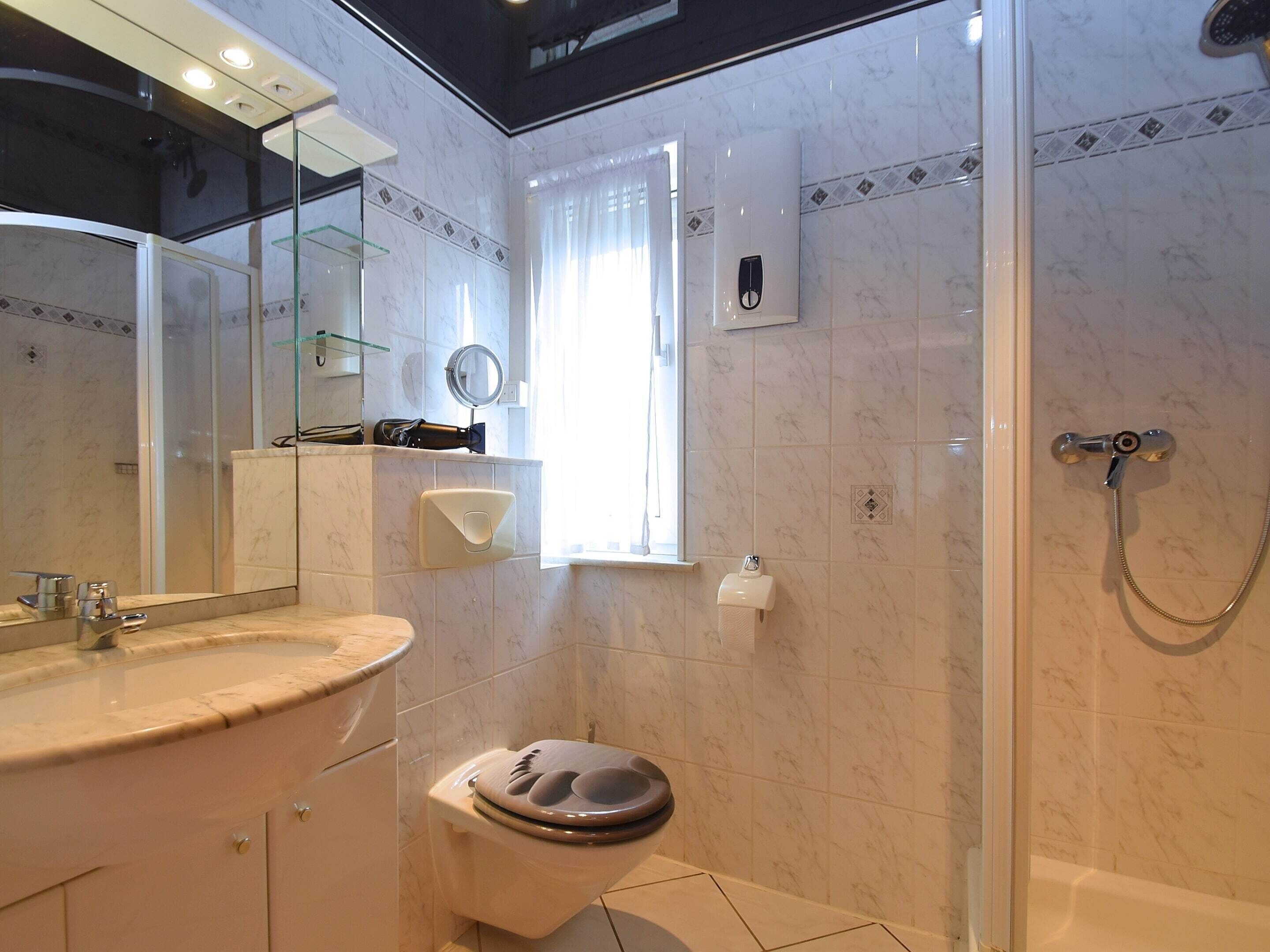 A bathroom with a toilet, sink, and shower.