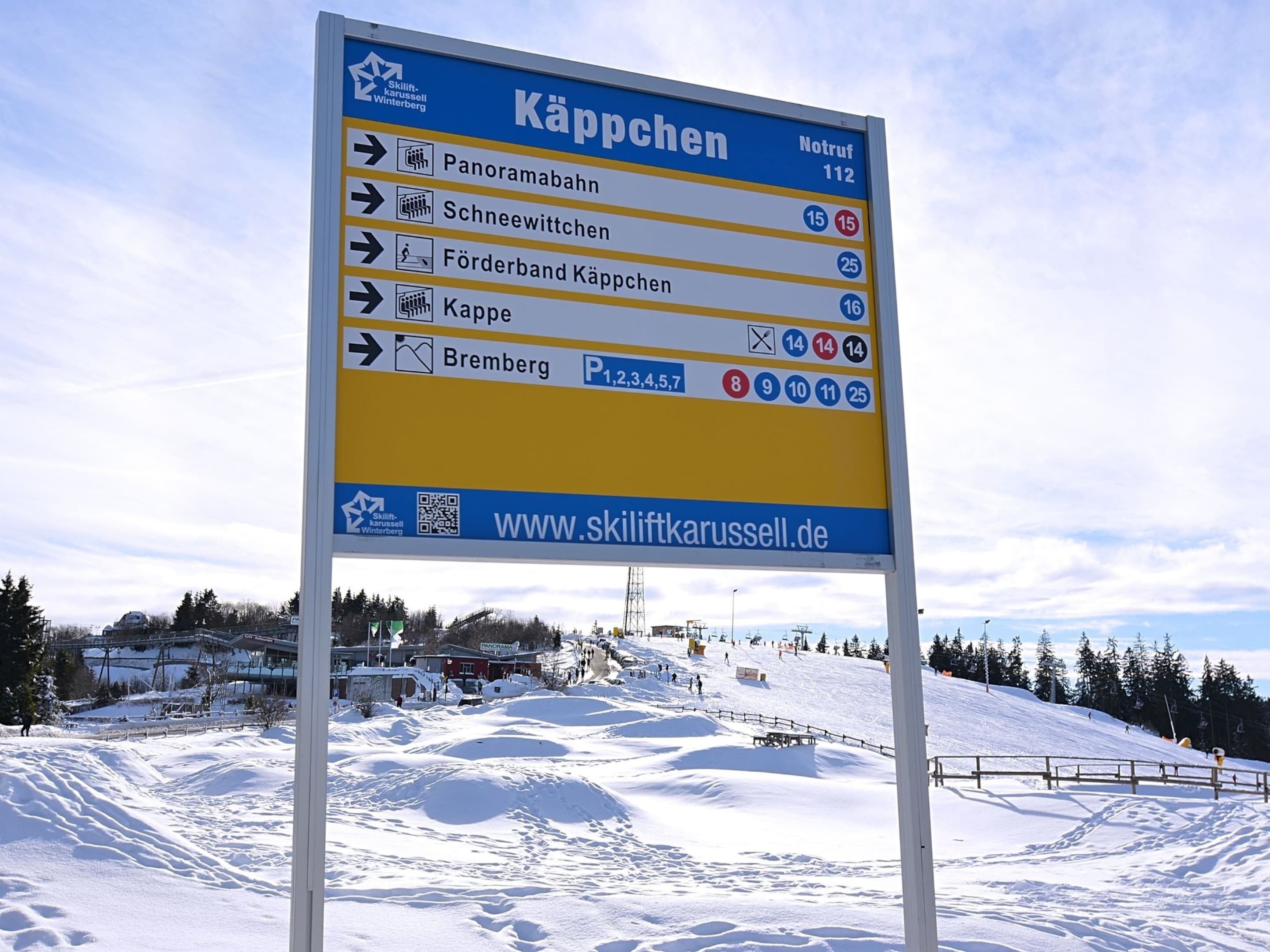 A sign with directions to various ski locations.