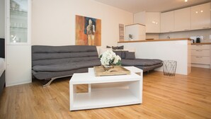 Una sala moderna con un sofá, una mesita de centro y un cuadro en la pared.