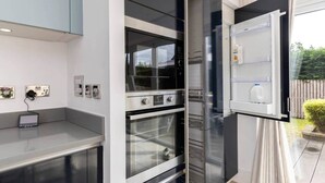 Een moderne keuken met inbouwapparatuur, een aanrecht en uitzicht op de omgeving.
