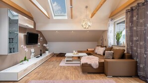 Uma sala de estar moderna no estilo loft, com pé direito alto, claraboia e um espaço de estar aconchegante com sofá e mesa de centro.
