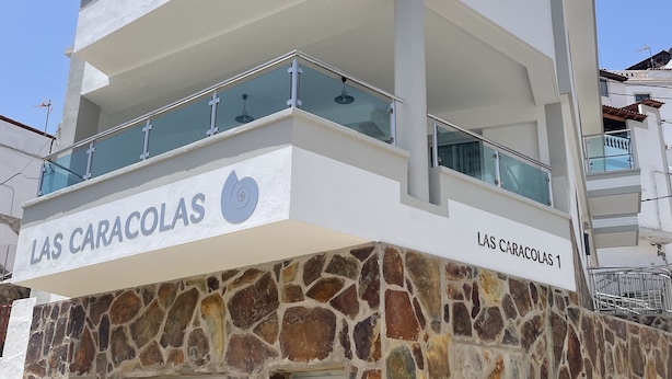 A multi-story building with a stone facade and balconies. - Apartments LAS CARACOLAS, Puerto de Mogán 1C (Puerto de Mogán)
