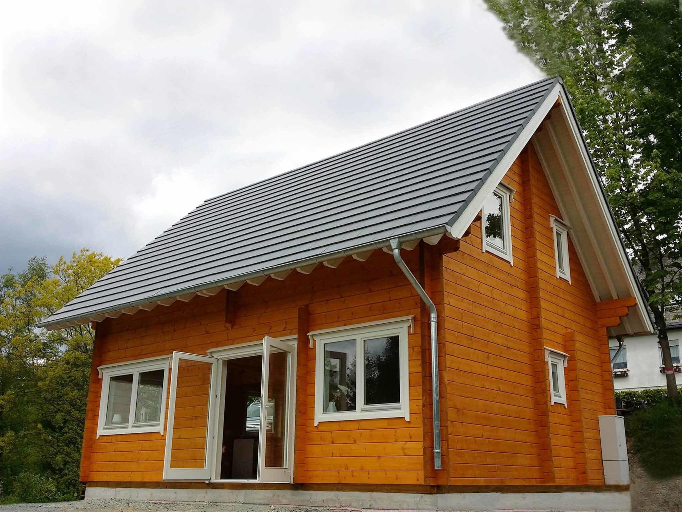 A small, single-story wooden house with a sloped roof and white trim around the windows and doors.