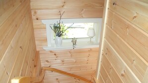 A wooden interior with a window, a white vase with branches, and a small table with a lamp. - Forest Escape Near Ski Lift (Medebach)