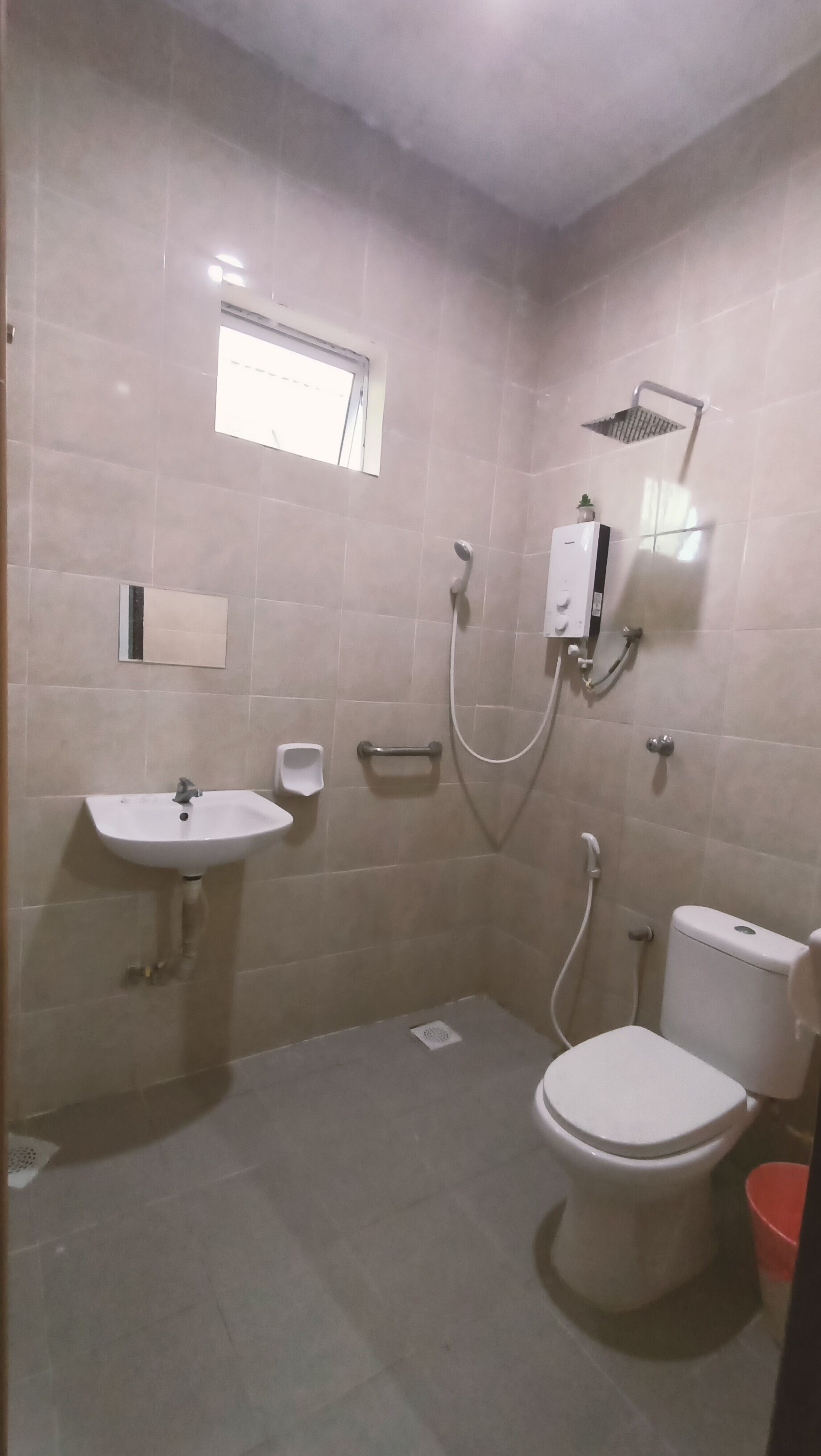 A bathroom with a toilet, sink, and shower.