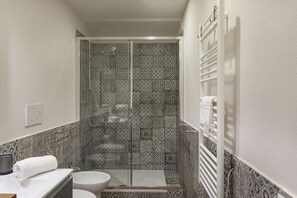A bathroom with a shower, toilet, and sink.
