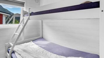 Una cama litera con escalera, una ventana que da a zonas verdes y una puerta.