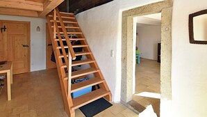 A wooden staircase leading to an upper floor, a door, and a mirror on the wall. - Hideaway With Hammock (Konzell)