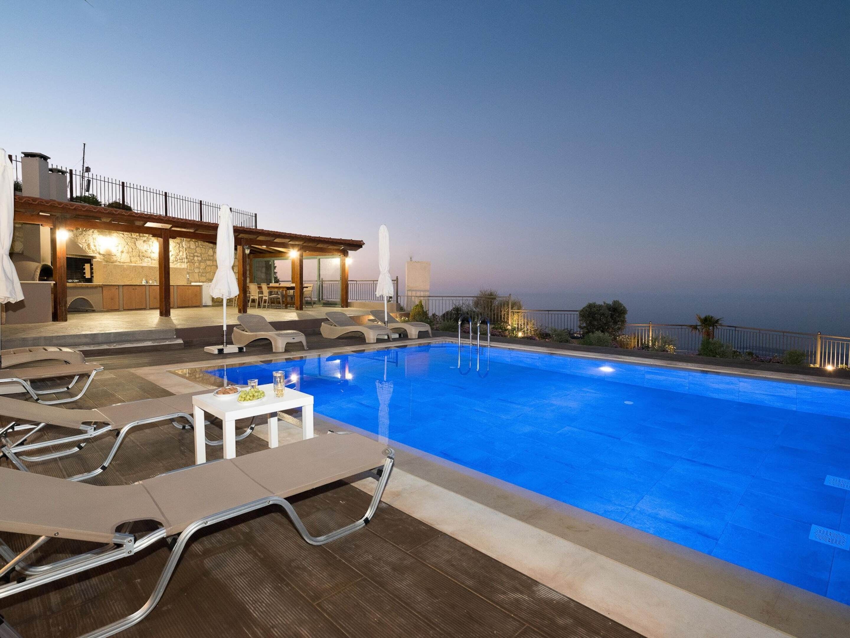 A rooftop pool with lounge chairs and a bar area.