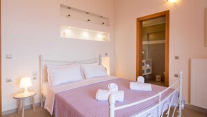 Une chambre à coucher bien rangée, avec un lit, des lampes de chevet et un miroir.