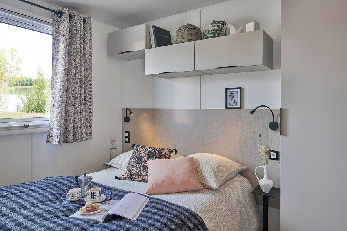 Ein Schlafzimmer mit einem Bett, einem Nachttisch und einem Fenster mit Vorhängen.