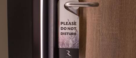 A door with a 'Please Do Not Disturb' sign and a keycard slot.