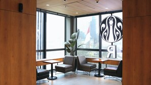 A modern indoor space with large windows, wooden paneling, and a central plant. - AI HOTEL JAKARTA THAMRIN (Jakarta)