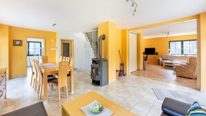 Amplia sala de estar con mesa de comedor, sofá y chimenea.