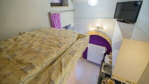 A bedroom with a bed, a TV, a window, and a bathroom. - Snug Apartment in Kournas With Balcony/terrace (Apokoronas)