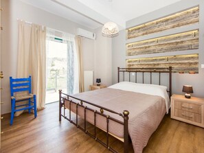 A bedroom with a wooden bed frame, a nightstand, a lamp, and a wall-mounted light fixture.
