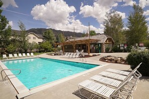 A swimming pool with lounge chairs, a wooden gazebo, and a mountain backdrop. - Beautiful 2 BR Moose Hollow Condo next to Hot Tub (Eden)