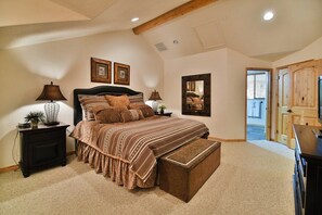 A bedroom with a large bed, two bedside tables, a bench, a mirror, and a door leading to another room. - Beautiful 2 BR Moose Hollow Condo next to Hot Tub (Eden)