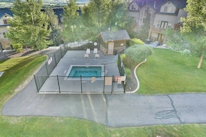 A residential backyard with a swimming pool, a fenced patio area, and a small house. - Beautiful 2 BR Moose Hollow Condo next to Hot Tub (Eden)