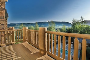 Eine Holzdiele mit Blick auf Berge und einen Pool.