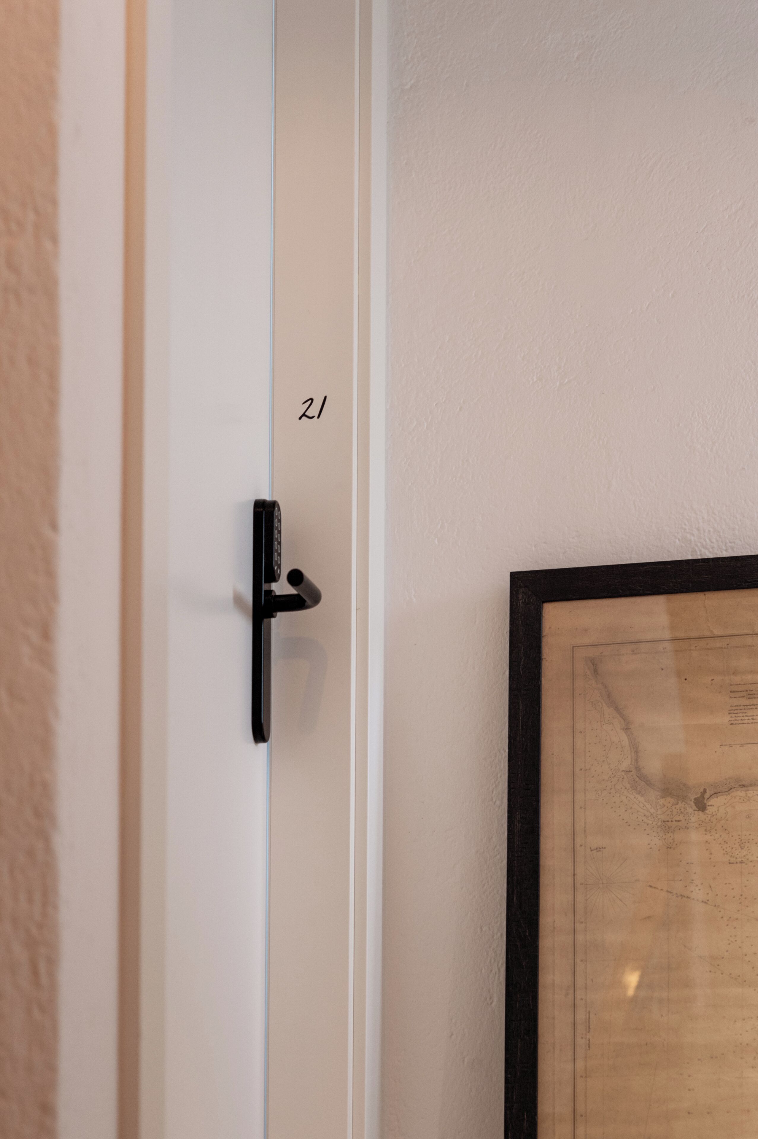 A door with a black handle and a number '21' on the wall beside it.