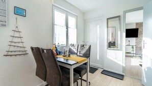 A modern dining area with a table, chairs, and a decorative wall piece. - Ferienhaus in Suhl in der Nahe des Rennsteigs (Suhl)