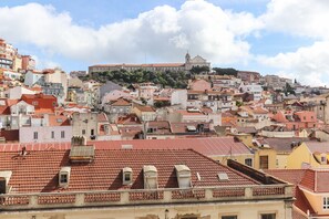 Un área urbana densamente poblada, con tejados de tejas rojas y una iglesia destacada en una colina.