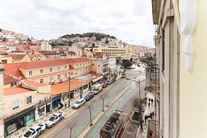 Un paisaje urbano con una colina destacada al fondo, una línea de tranvía y varios edificios de diferentes estilos arquitectónicos.