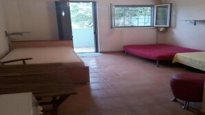 A room with a bed, a bench, a small table, and a window. - Cheerful Holiday Home in Preveza With Garden (Preveza)