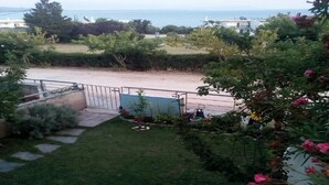 A view of a garden with a lawn, a pathway, and a metal fence. - Cheerful Holiday Home in Preveza With Garden (Preveza)