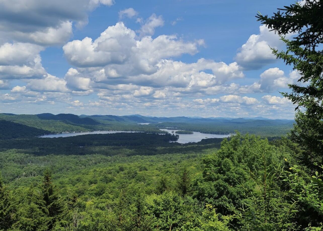 A view of a lake surrounded by forested hills.