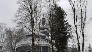 A snow-covered building with a dome roof, surrounded by trees. - Cosy Holiday Home Near the ski Lift (Grossbreitenbach)
