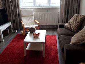Relax in this stylish living space with a comfortable sofa, coffee table, and ample seating options.