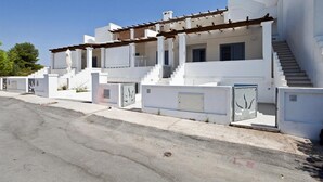A modern white building with a covered outdoor area and a staircase leading to the upper floor. - 199 Casa a 500m dal Mare a S M di Leuca (Castrignano del Capo)