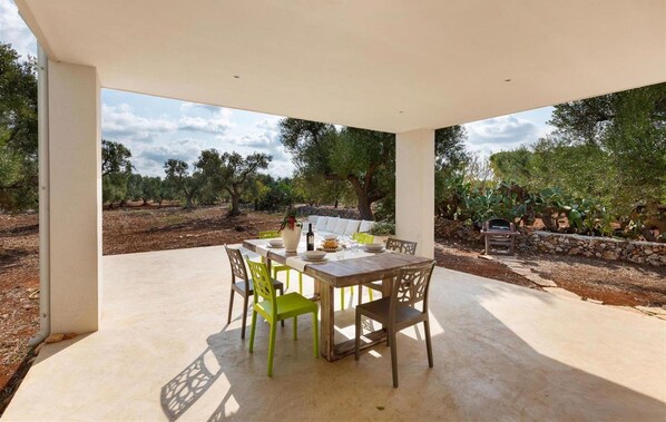 An outdoor patio with a table set for four, surrounded by chairs, under a white canopy. - 2166 Villa Magal by Perle di Puglia (Carovigno)
