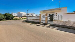 A modern building with a gated entrance, a stone wall, and a clear blue sky. - 2203 Villa Lucia - Bilo 1 by Barbarhouse (Nardò)